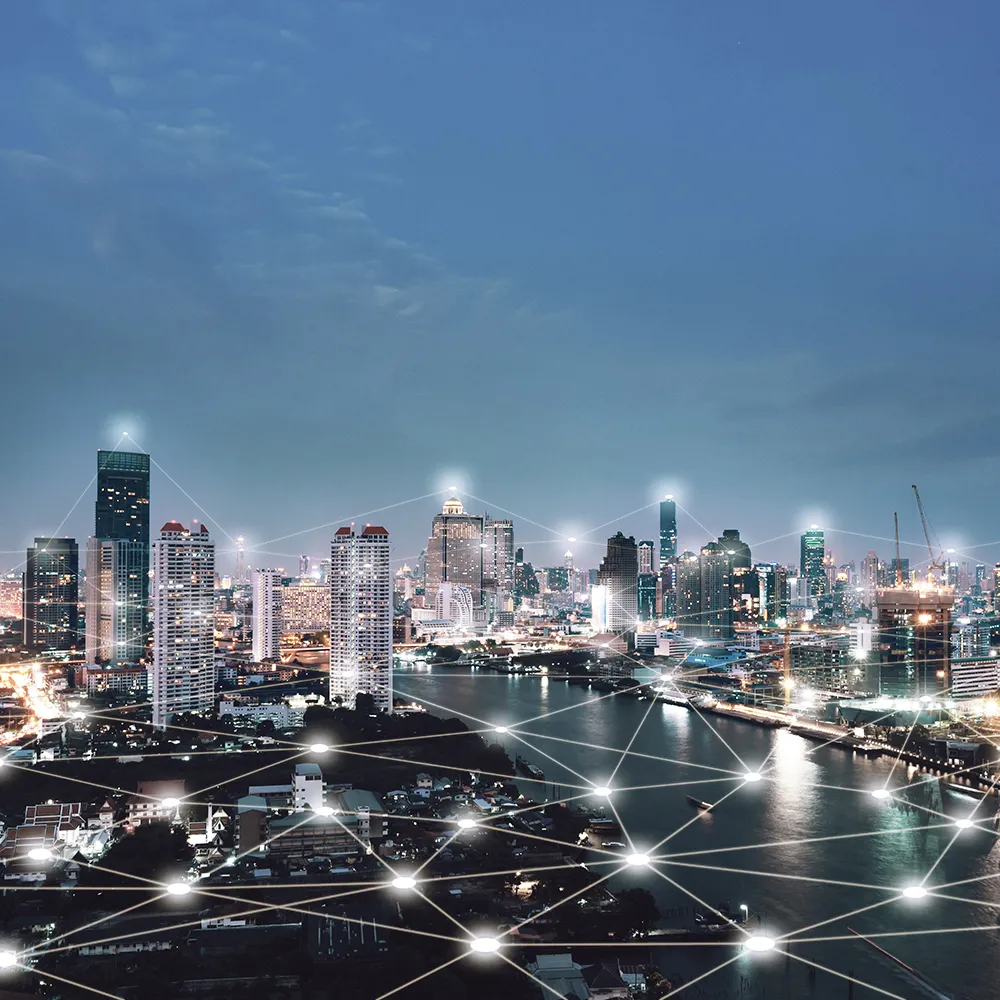 Bird's-eye view of a city with a river at night, in which many points are virtually connected by lines.