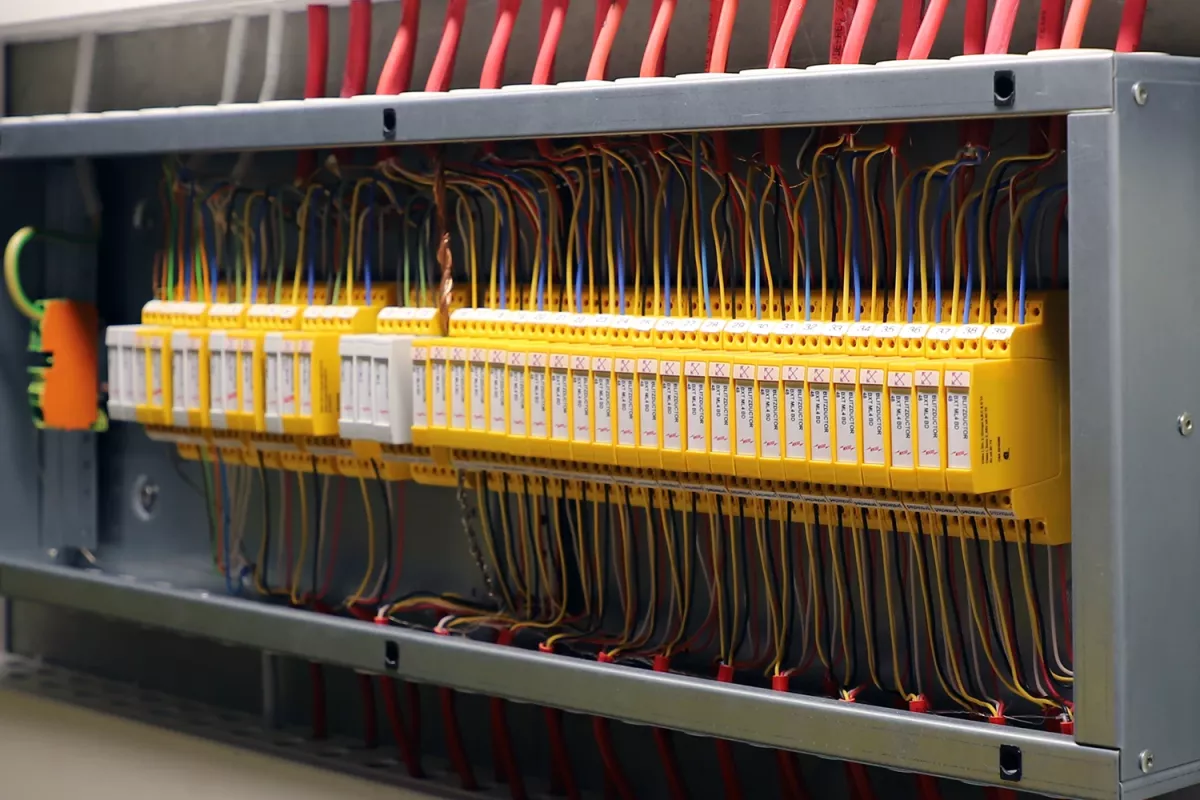 A close-up view of an open electrical control panel with multiple wires connected to yellow terminal blocks.